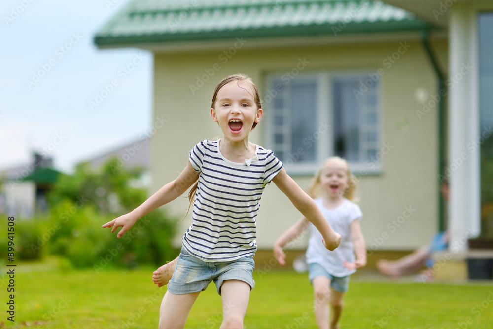 Obraz premium Two adorable little sisters having fun outdoors