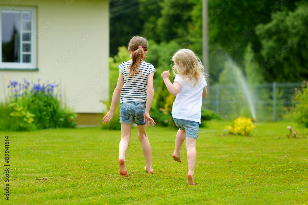 Obraz premium Two adorable little sisters having fun outdoors
