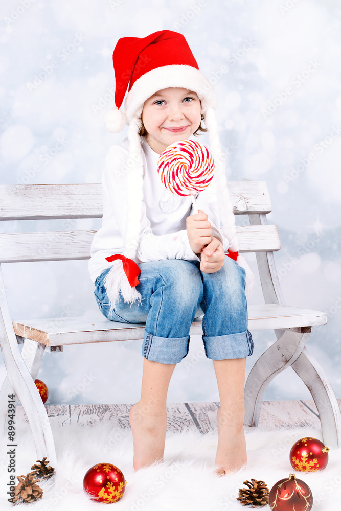 Obraz premium young girl in Santa's hat with christmas lollipop