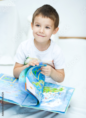 Little boy is reading a book