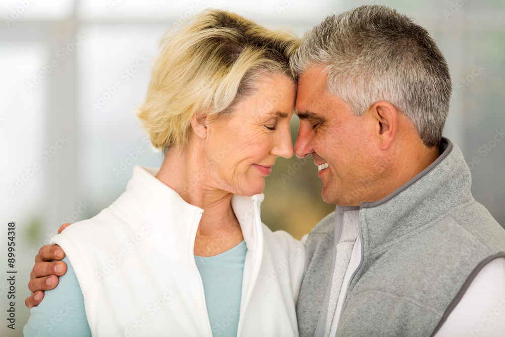 middle aged couple hugging with eyes closed middle aged couple hugging with eyes closed