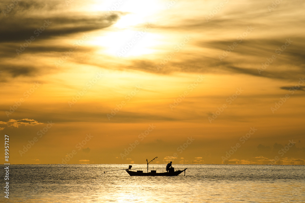 silhouette of fishermen in the boat on sea with yellow and orange sun in the background silhouette of fishermen in the boat on sea with yellow and orange sun in the background