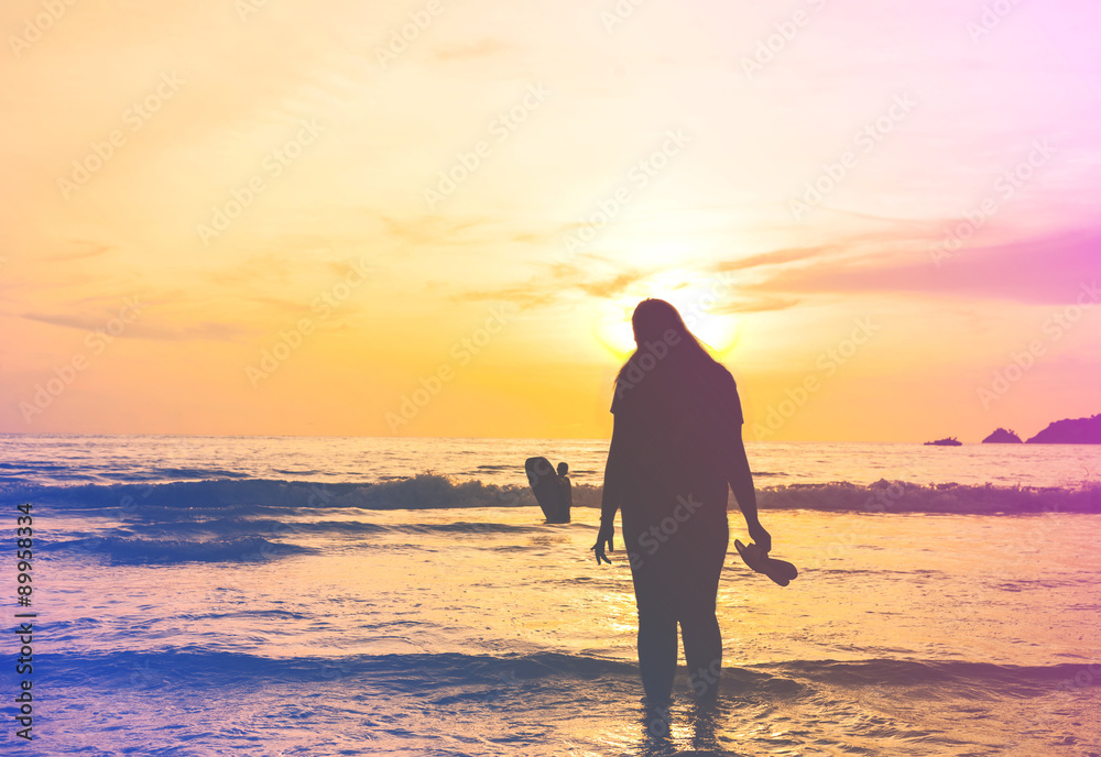 Silhouette vintage women in the sea with color of the sunset