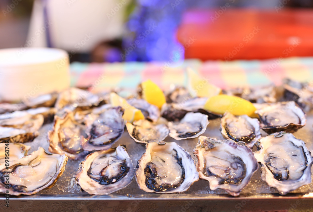 Freash oysters on ice tray and lemon