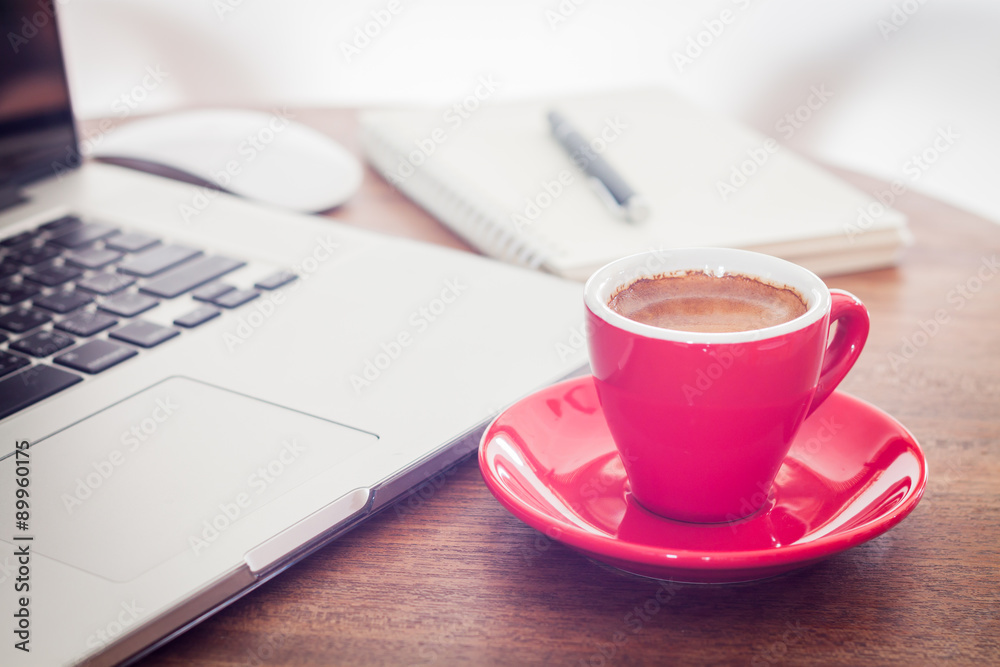 Red coffee cup with notepad and laptop Red coffee cup with notepad and laptop