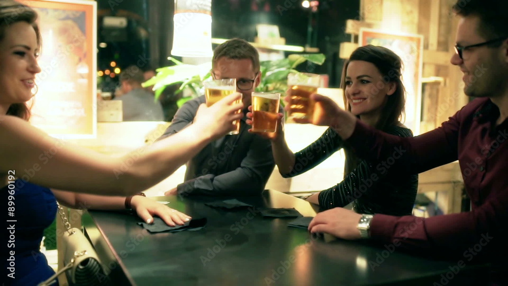 Friends chatting in the pub and drinking beer, steadycam shot
