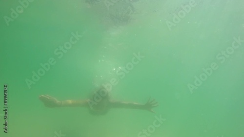 Woman Swimming Underwater in the Sea. Slow Motion.  photo