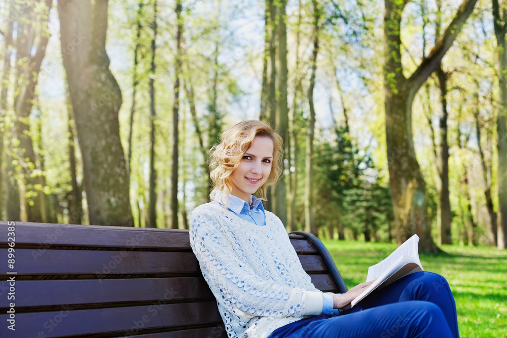 young student girl in shirt sitting with a book in her hand in a green park, science and education, reading, people concept young student girl in shirt sitting with a book in her hand in a green park, science and education, reading, people concept