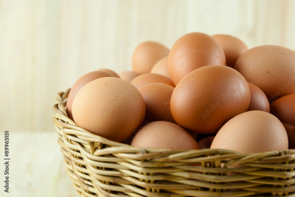 Full of Eggs put in a wicker basket in wooden background Full of Eggs put in a wicker basket in wooden background