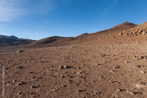 Deserto del Dali. Montagne e rocce in una distesa di sabbia. Cielo blu e montagne sullo sfondo