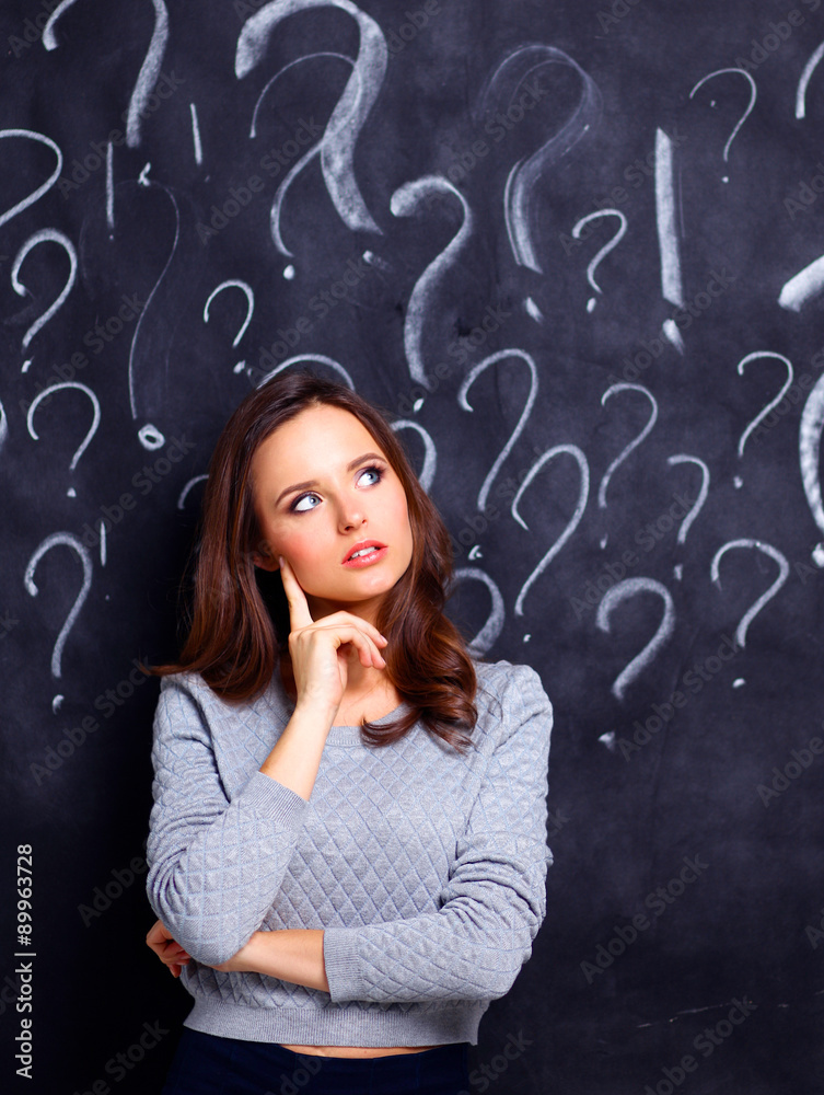 Young girl with question mark on a gray background Young girl with question mark on a gray background