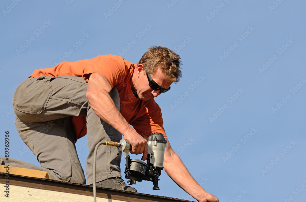 Building contractor putting the asphalt roofing on a large commercial apartment building. Building contractor putting the asphalt roofing on a large commercial apartment building.