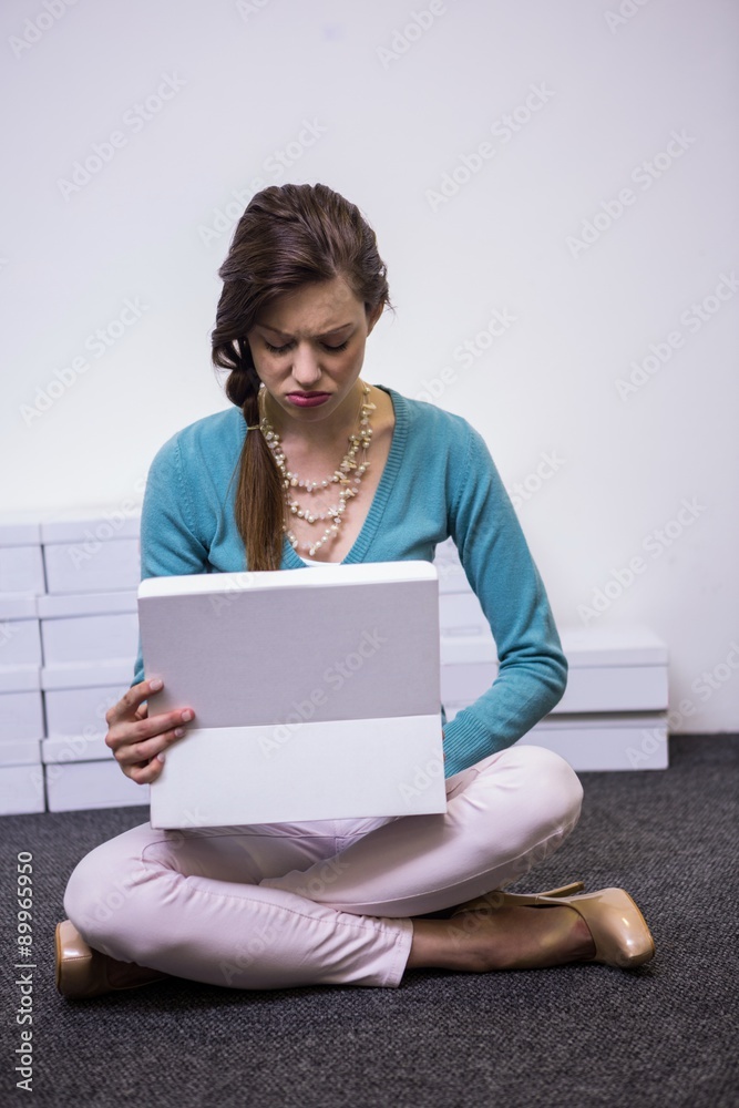Sad brunette looking in shoe box Sad brunette looking in shoe box