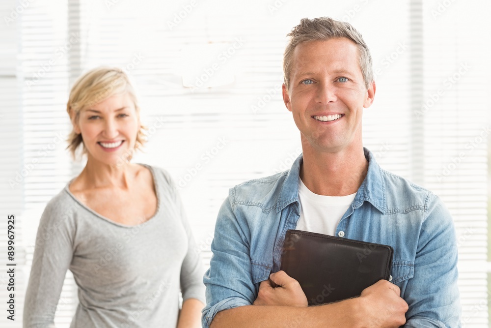 © WavebreakmediaMicro - Smiling business colleagues holding a tablet