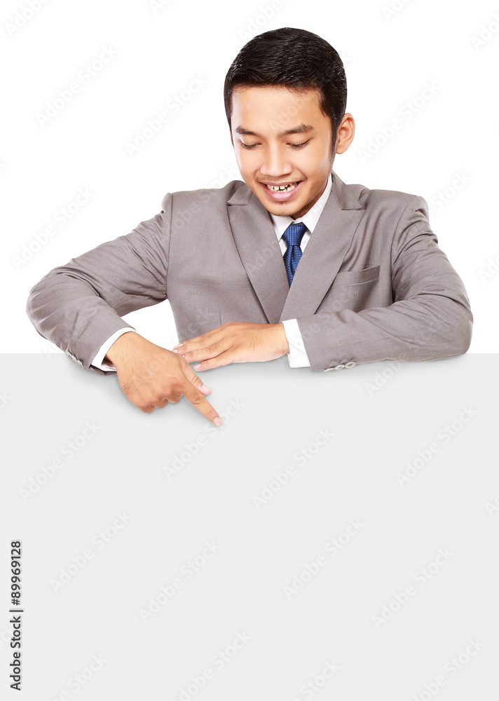 Young businessman pointing at a blank board, isolated on white background Young businessman pointing at a blank board, isolated on white background