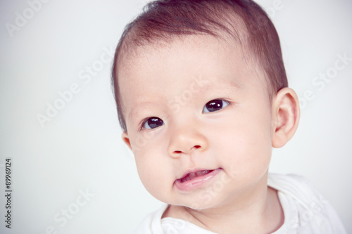 Cute asian baby laughing on white background  studio shot  soft
