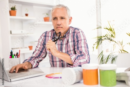 Thoughtful casual businessman sitting at working desk