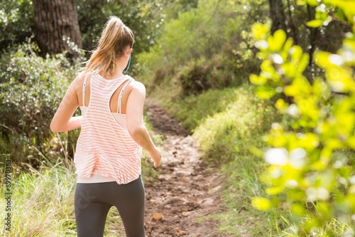 Fototapeta Naklejka Na Ścianę i Meble -  Blonde athlete jogging on trail
