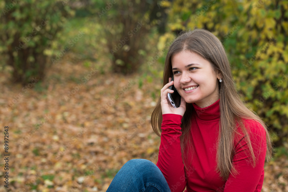 Young woman talking on mobile phone in fall Young woman talking on mobile phone in fall