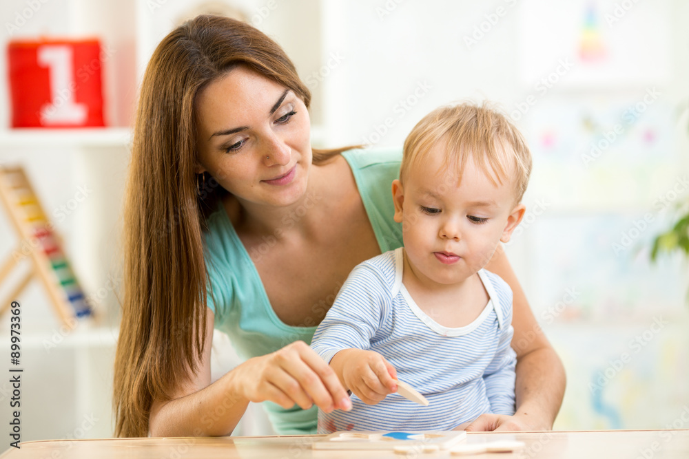 mother playing puzzle together with her son mother playing puzzle together with her son