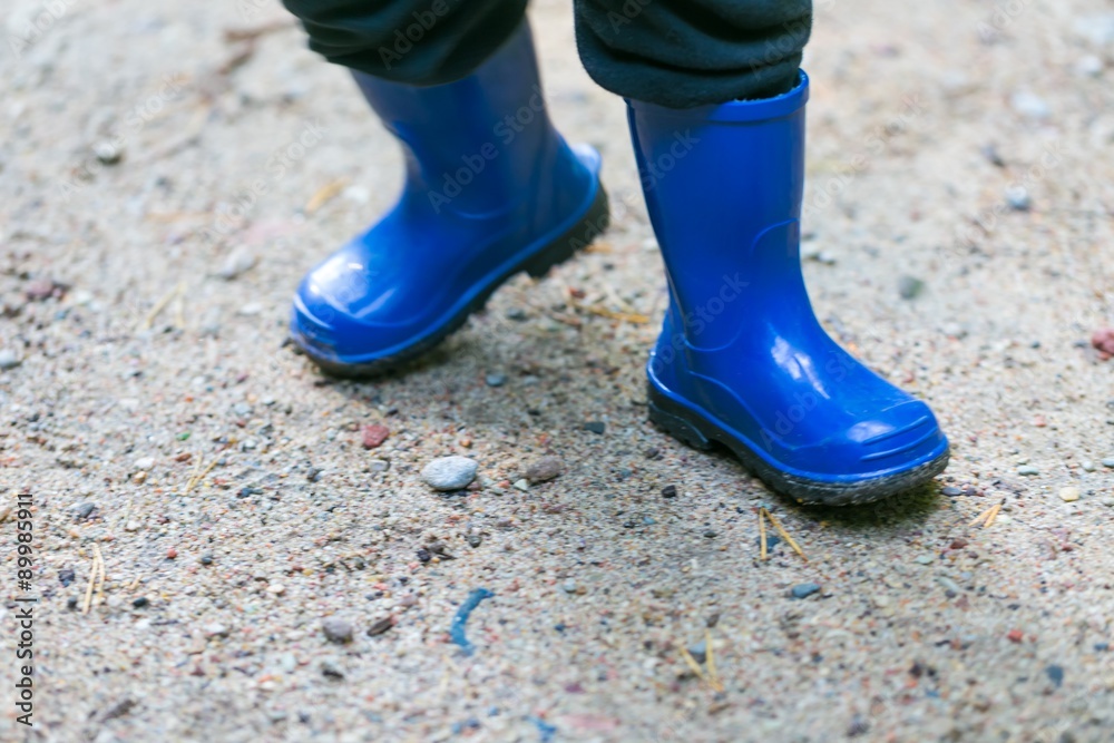 Little child legs in rain boots