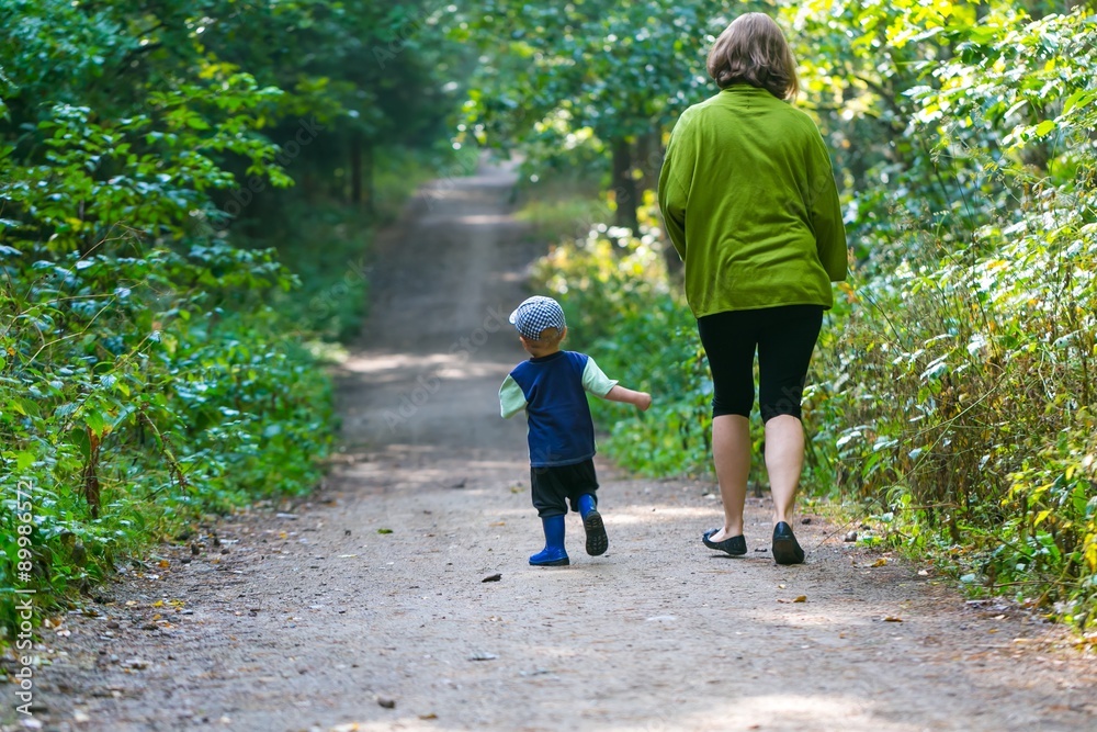 Fototapeta premium Little boy and mother running and playing in forest at summer.