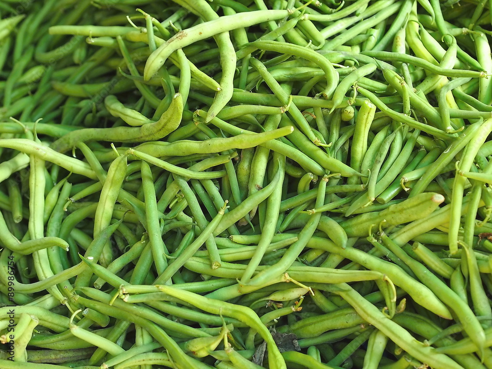 Pile of fresh green bean legume (hull) at farmers market stall.