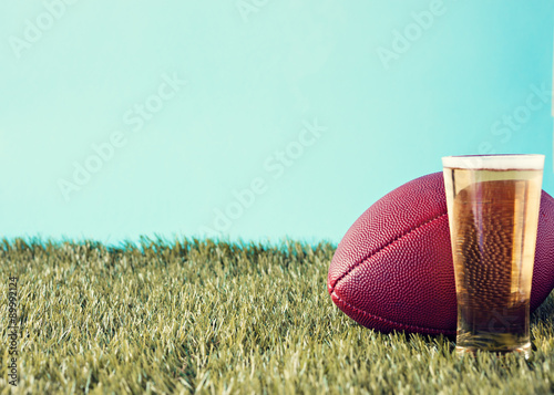 Vintage football over grass and beer glass