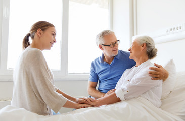 happy family visiting senior woman at hospital