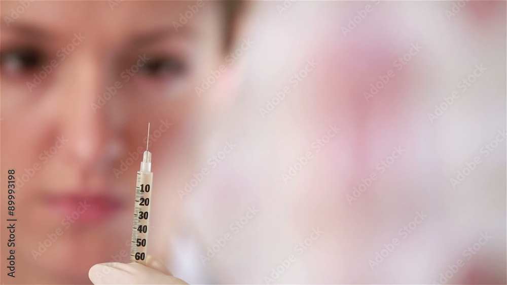 Female doctor preparing a syringe for injection. Female doctor preparing a syringe for injection.