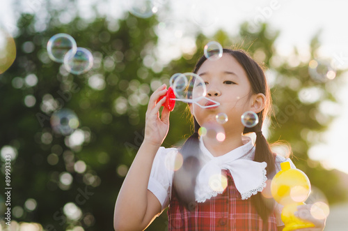 Cute asian girl is blowing a soap bubbles  Outdoor Portrait