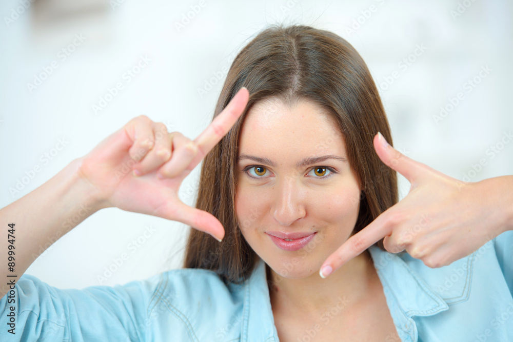 Fototapeta premium Girl framing face with hands