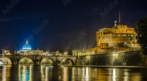 Night view over tiber river, saint peters basiica, castel sant angelo and ponte sant angelo in rome photo