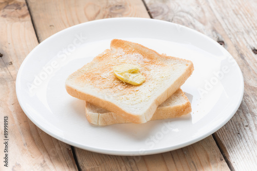 Slice of bread toast on a white plate.