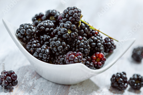 Fresh blackberries bowl on white wooden table