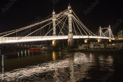 Albert Bridge, illuminated at night spans the River Thames, London.