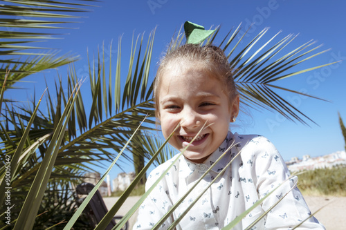 Una niña rubia jugando en el parque. Niña rubia disfrutando del verano rodeada de árboles. Primer plano de preciosa niña rubia. photo