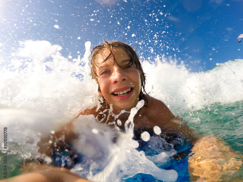 boy enjoys riding the waves with a surfboard