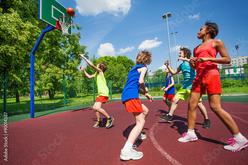 Teenagers in colorful uniforms playing basketball © Sergey Novikov