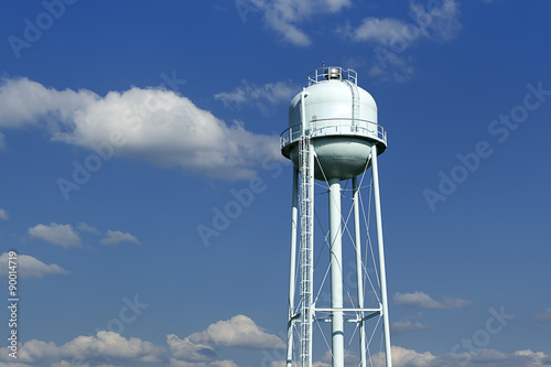 A water tower with a lightly cloudy sky in the background. photo