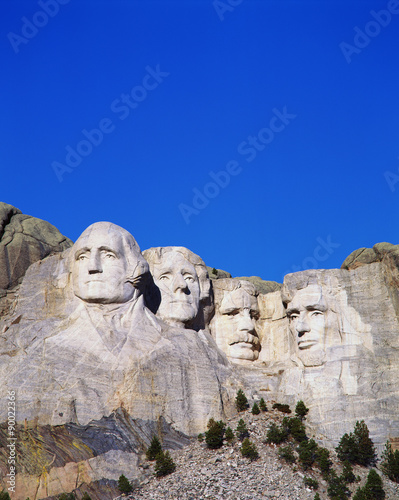 This is a vertical image of Mount Rushmore National Monument showing the four faces of George Washington, Thomas Jefferson, Theodore Roosevelt, and Abraham Lincoln. photo