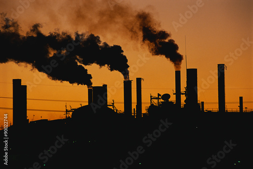This is a Ford factory at sunset. These are smokestacks contributing to the pollution in the air. photo