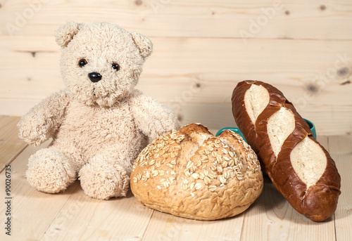 bear toy with bread on wood