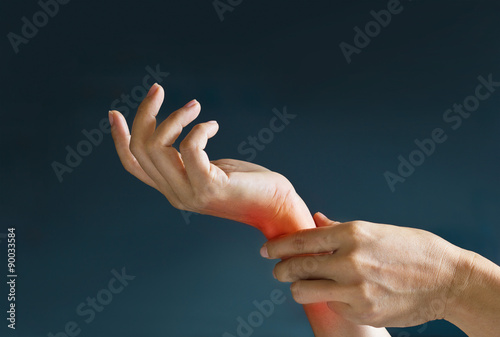 Canvastavla Acute pain in a woman wrist, colored in red on dark blue background