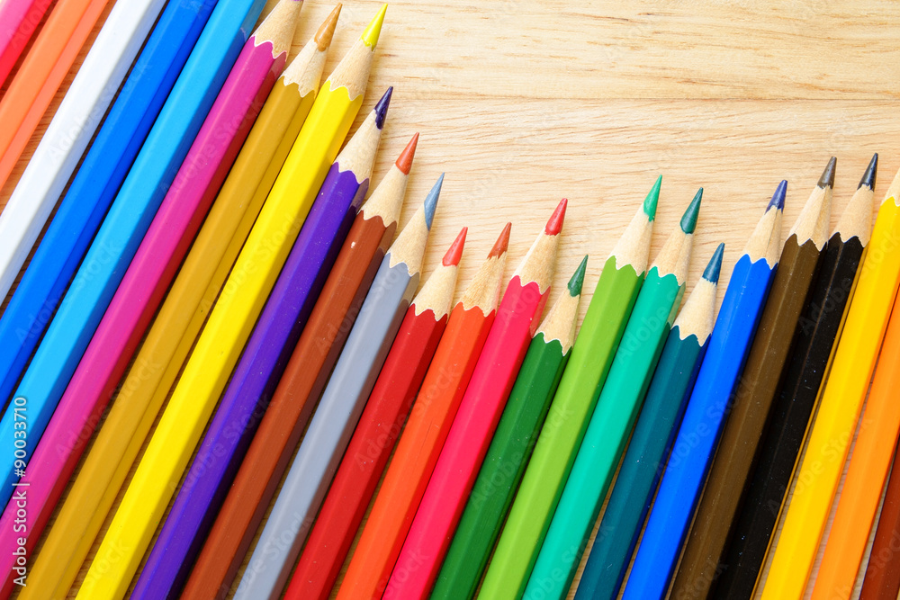Fototapeta premium Color pencils on wood background