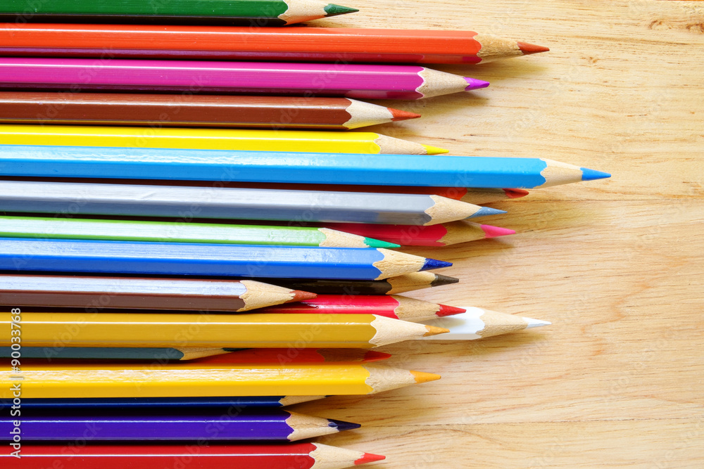 Fototapeta premium Color pencils on wood background