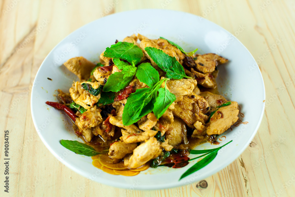 Spicy Thai basil chicken ready to eat on traditional plate Spicy Thai basil chicken ready to eat on traditional plate