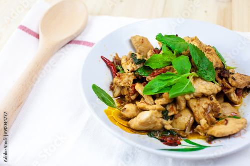 Spicy Thai basil chicken ready to eat on traditional plate. (Shallow aperture intended for the aesthetic quality of the blur.)