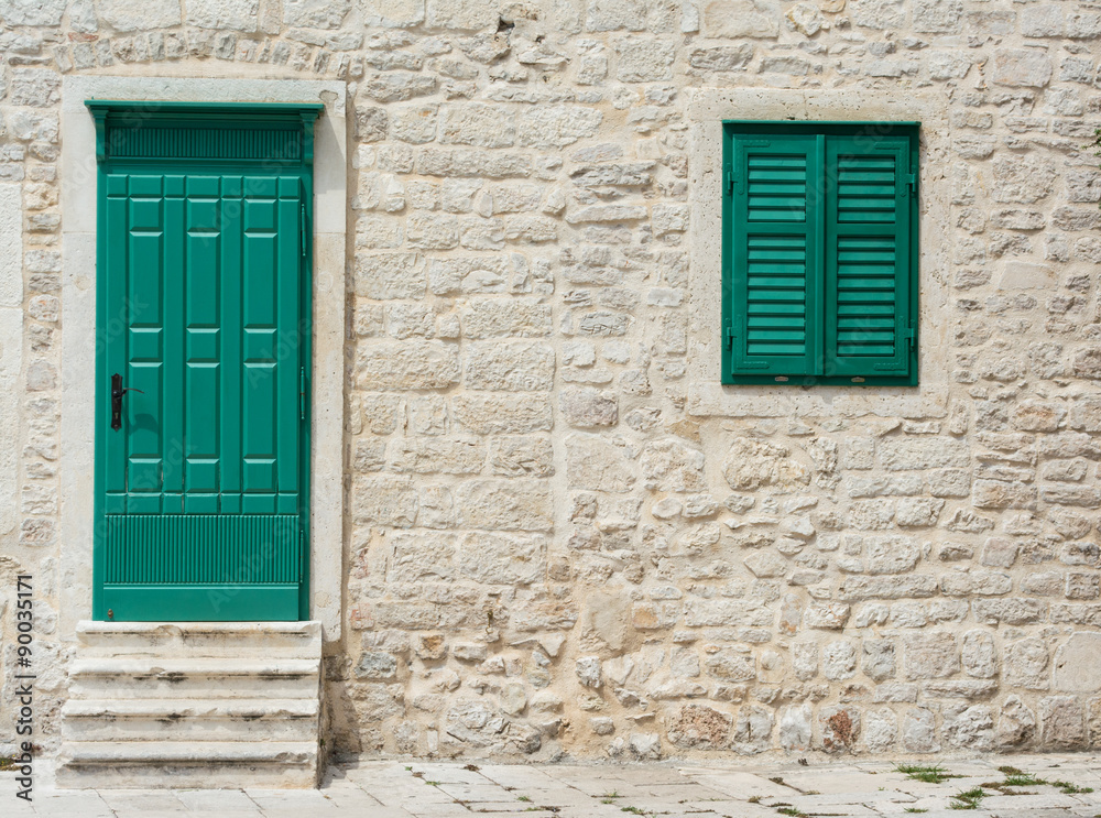 Wooden door and window with closed wooden shutters