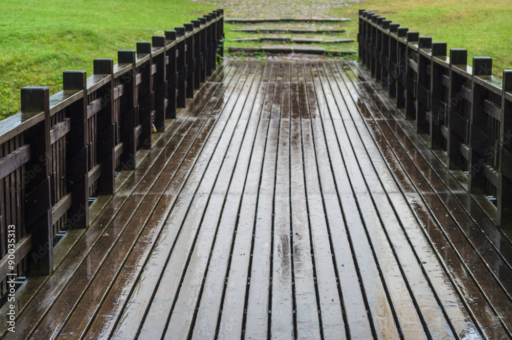 Blurred view of wet wooden bridge on rainy weather Blurred view of wet wooden bridge on rainy weather